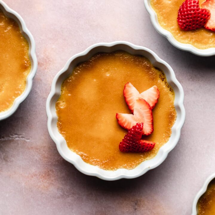 Keto Crème Brûlée in ramekins with strawberries