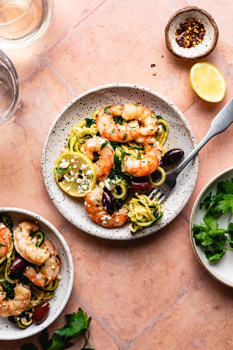 a plate of Mediterranean shrimp on zucchini noodles and fresh lemon