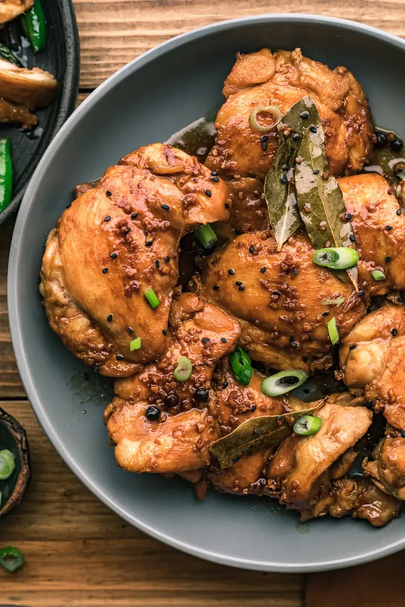 Filipino chicken adobo in a gray bowl on a wood table.