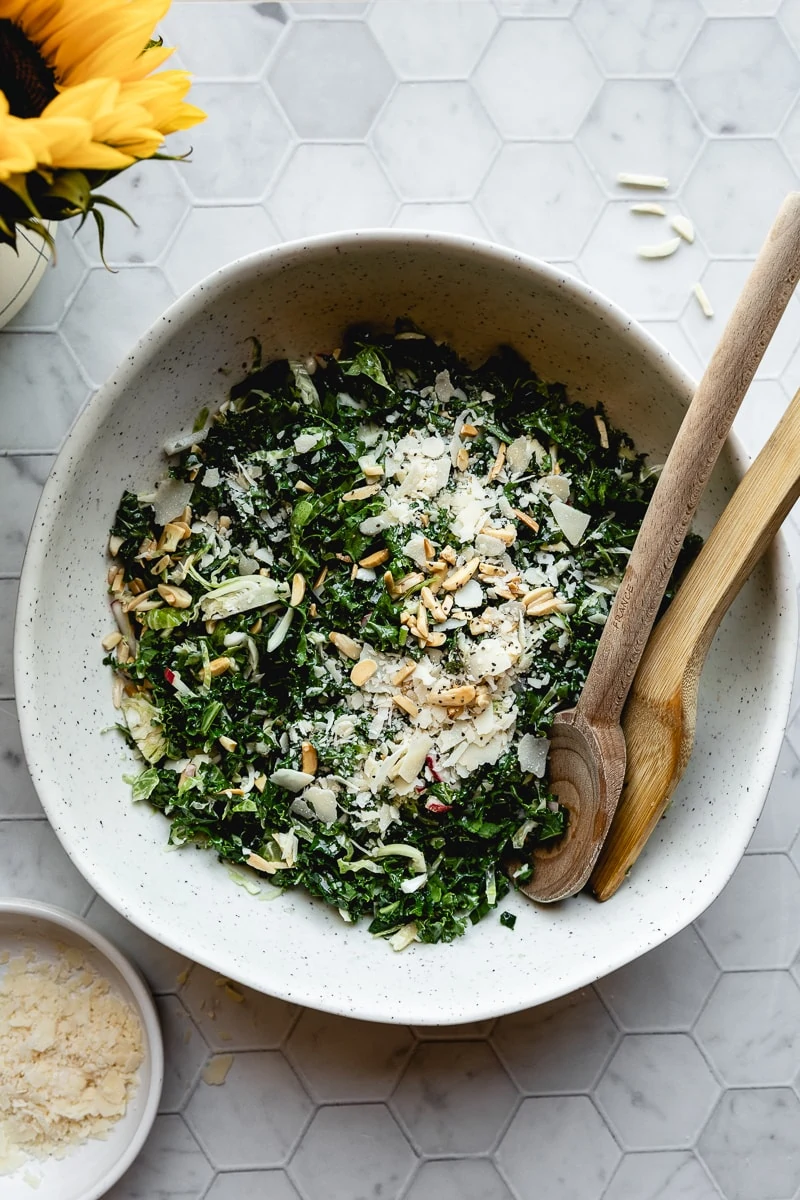 Large bowl of Chick Fil A kale salad with two wooden spoons.