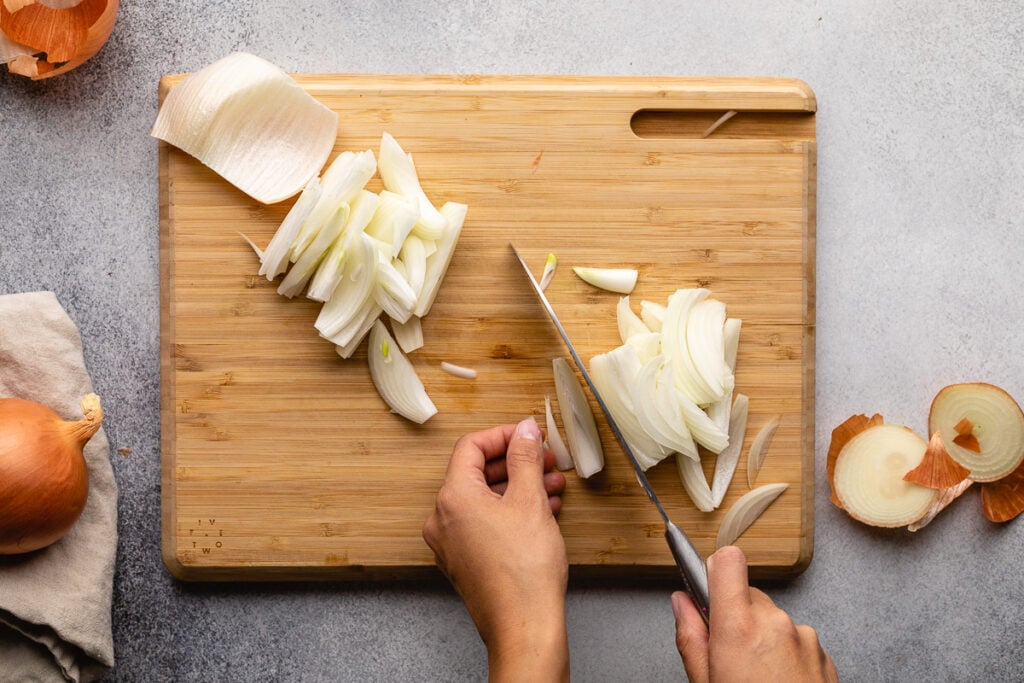 Slicing onions on a cutting board.