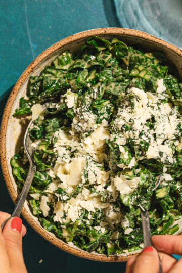 Tossing parmesan into bed of kale.