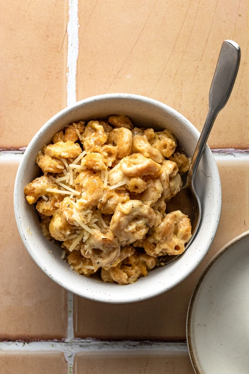 Bowl of low-carb mac and cheese on a tile background.