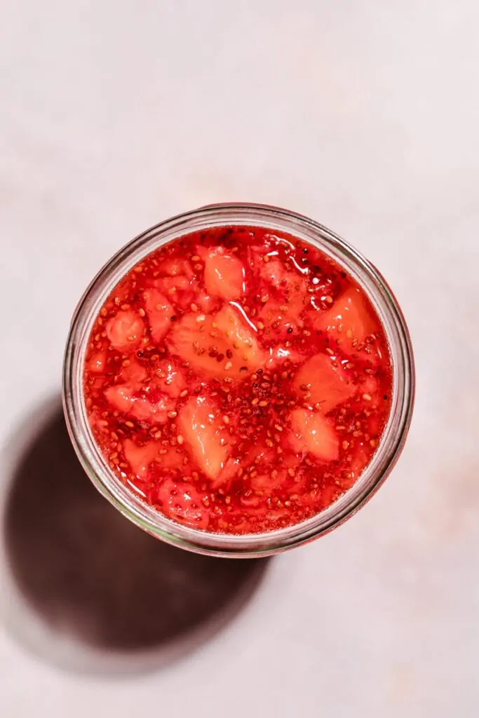 Overhead shot of strawberry jam in a jar.