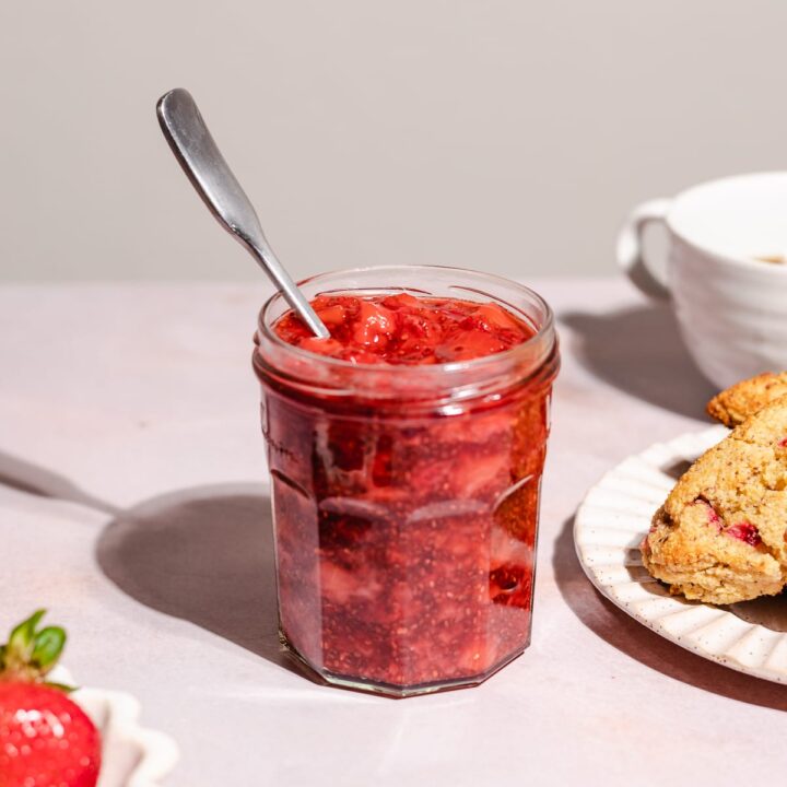 Keto strawberry jam in a jar with a spoon.