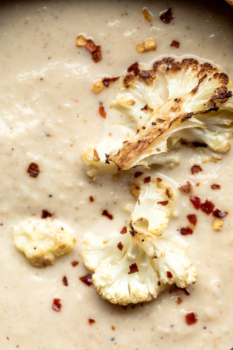 Closeup of roasted cauliflower as garnish on top of low carb cauliflower soup.