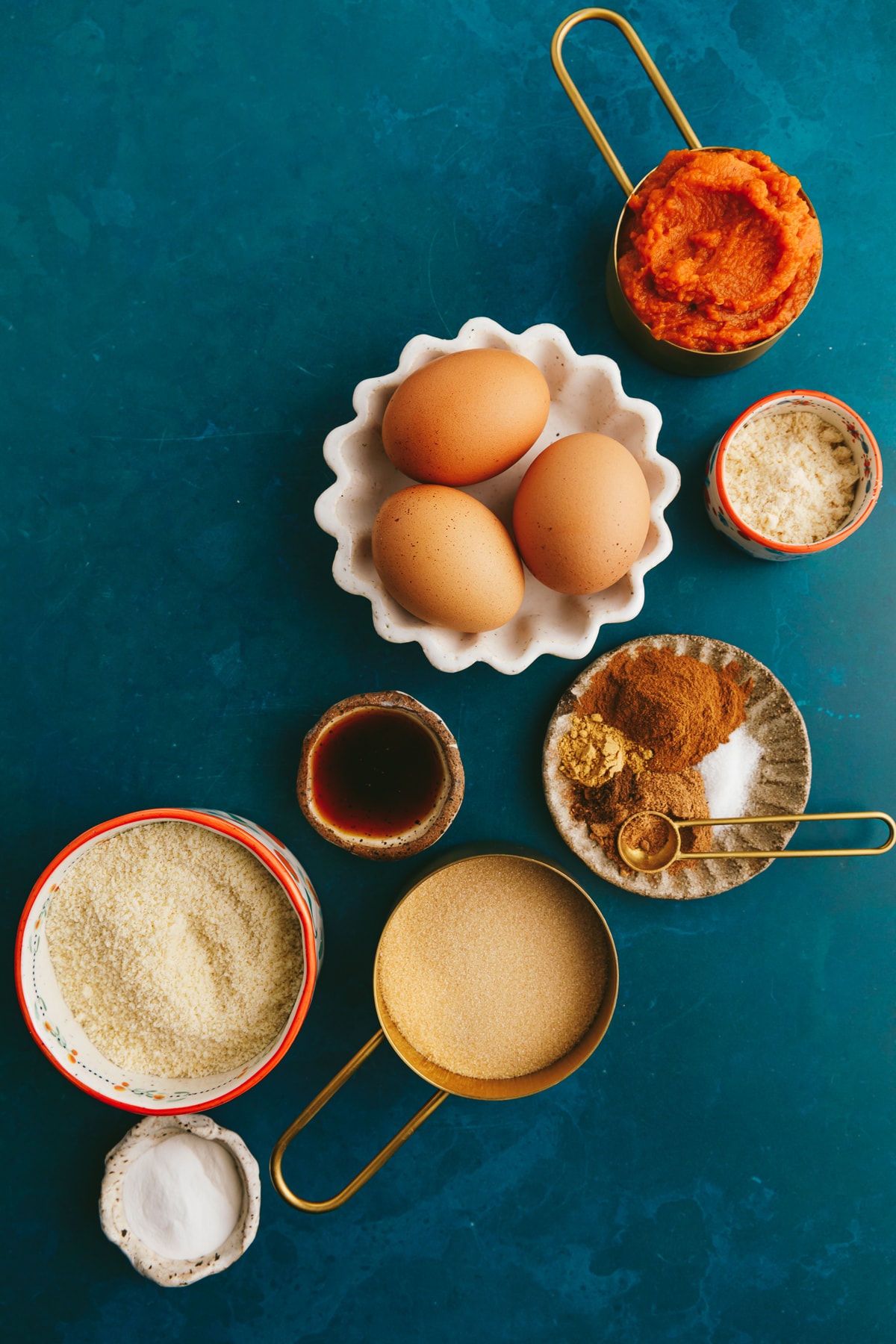 Ingredients for keto pumpkin roll recipe on a turquoise backdrop.