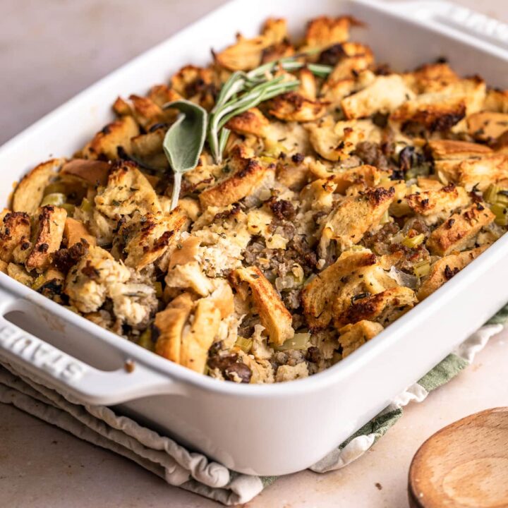 Baked keto sausage stuffing in a serving dish with fresh herbs on top.