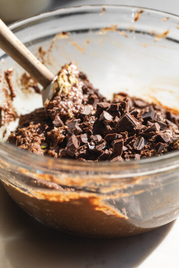 Closeup of keto chocolate zucchini bread batter with chunks of chocolate stirred in.