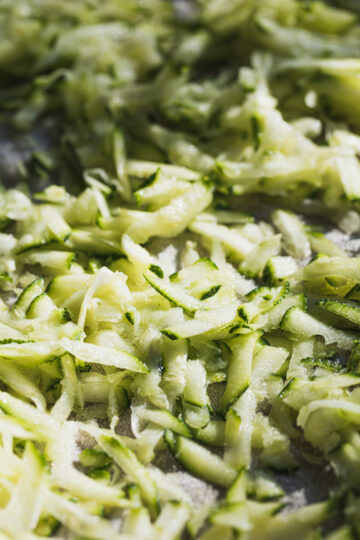 Closeup of shredded zucchini on tray.