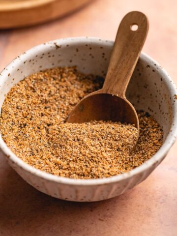 Low carb fajita seasoning in a small bowl with a wooden tablespoon.