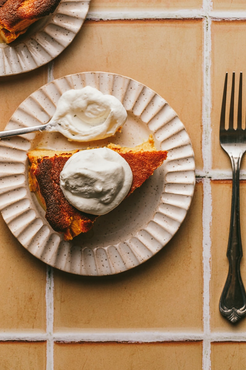 A slice of pumpkin Basque cheesecake on a white plate.