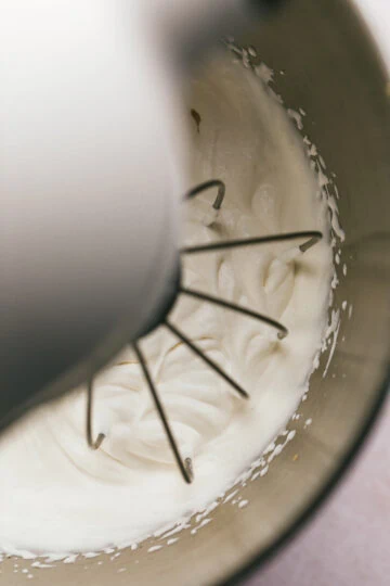 Overhead image of standup mixer beater mixing sugar-free whipped cream.