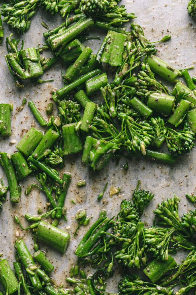 Closeup of broccolini on roasting pan.