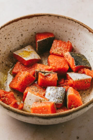 Closeup of salmon cubes in a bowl.