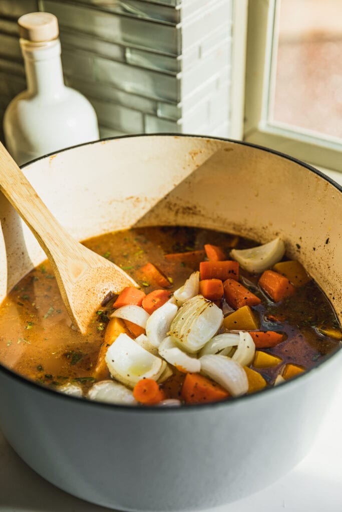 Roasted vegetables in a large pot for butternut squash carrot soup.