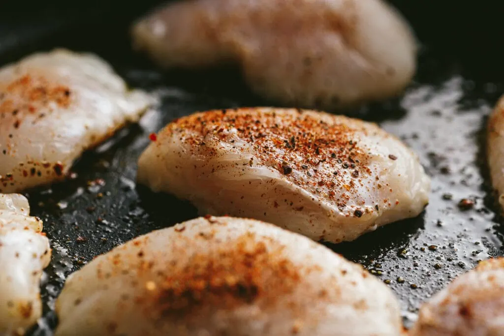 Closeup of halibut cheeks in a nonstick skillet.