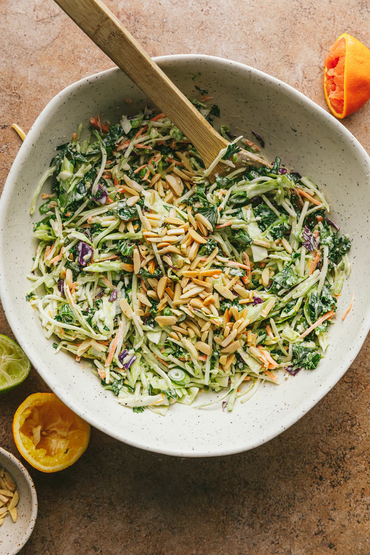 Crunchy citrus slaw in a white bowl with citrus around it.