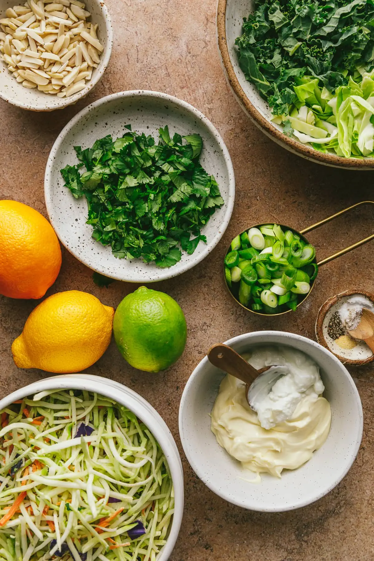 ingredients for citrus slaw on a brown backdrop.