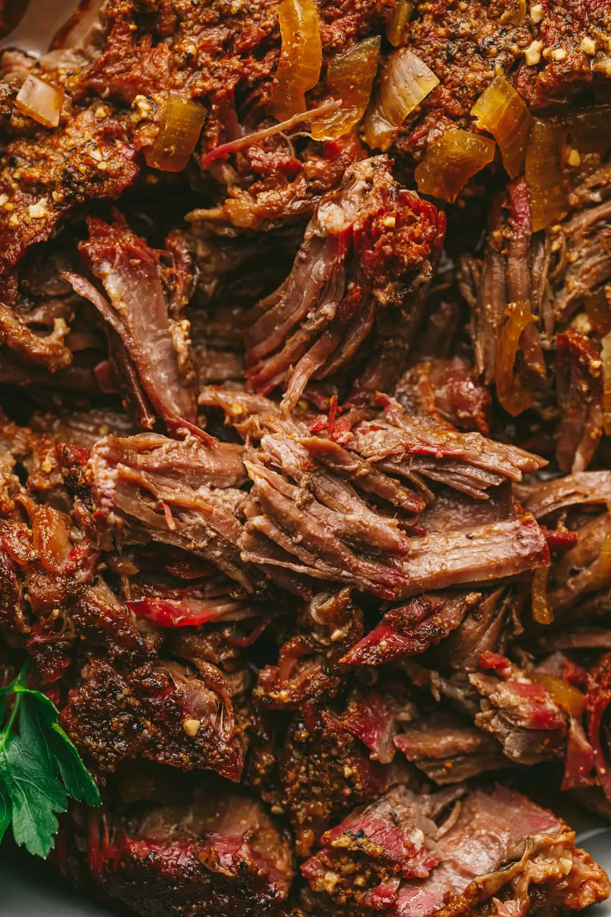 Closeup of smoked chuck roast shredded in a dish.