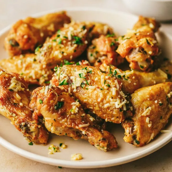 A plate of wings with garlic parmesan wing sauce.