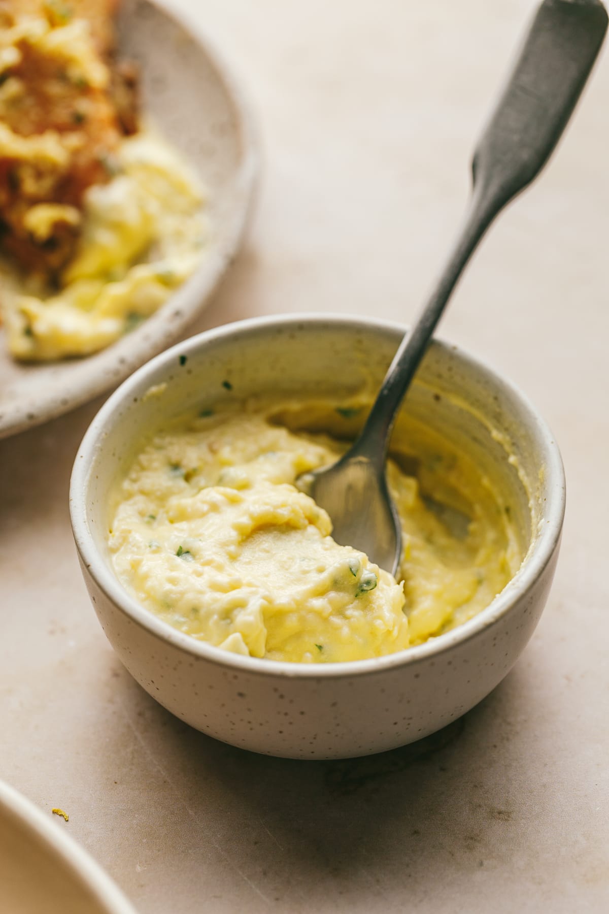 Garlic parmesan dip sauce in a dish with a spoon.