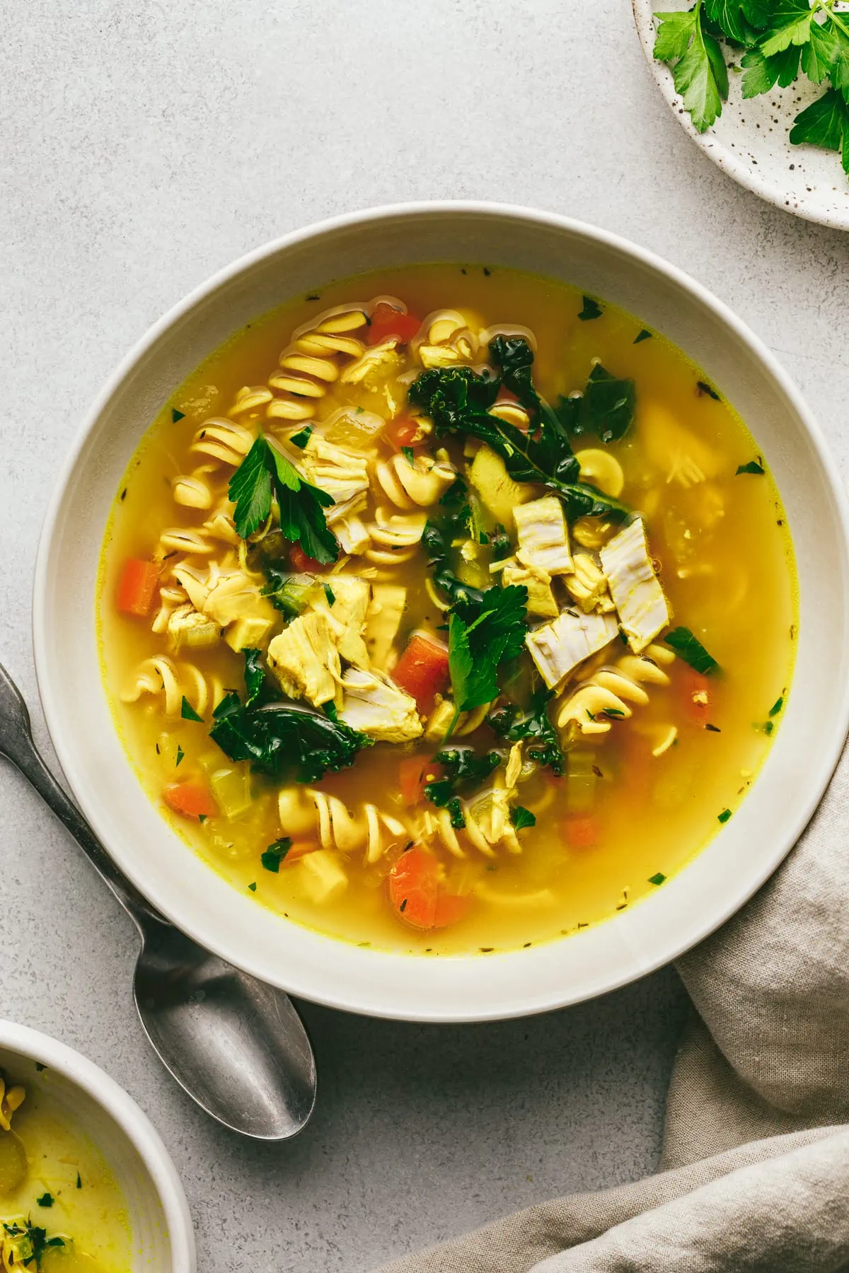 Keto chicken noodle soup in a white bowl on a countertop.