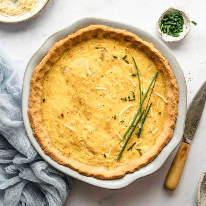 Keto quiche Lorraine in a pie dish with fresh chives.