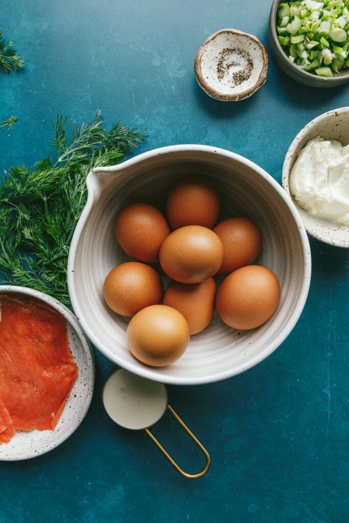 Ingredients for keto egg bites on a teal background.