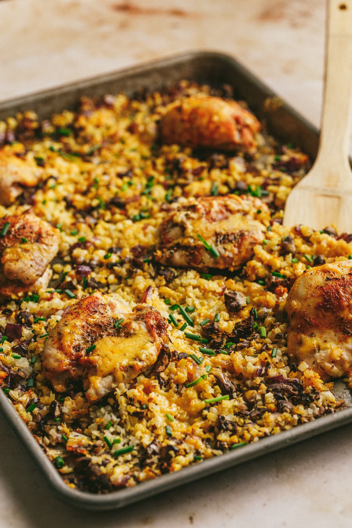 A sheet pan with cooked chicken and cauliflower rice.