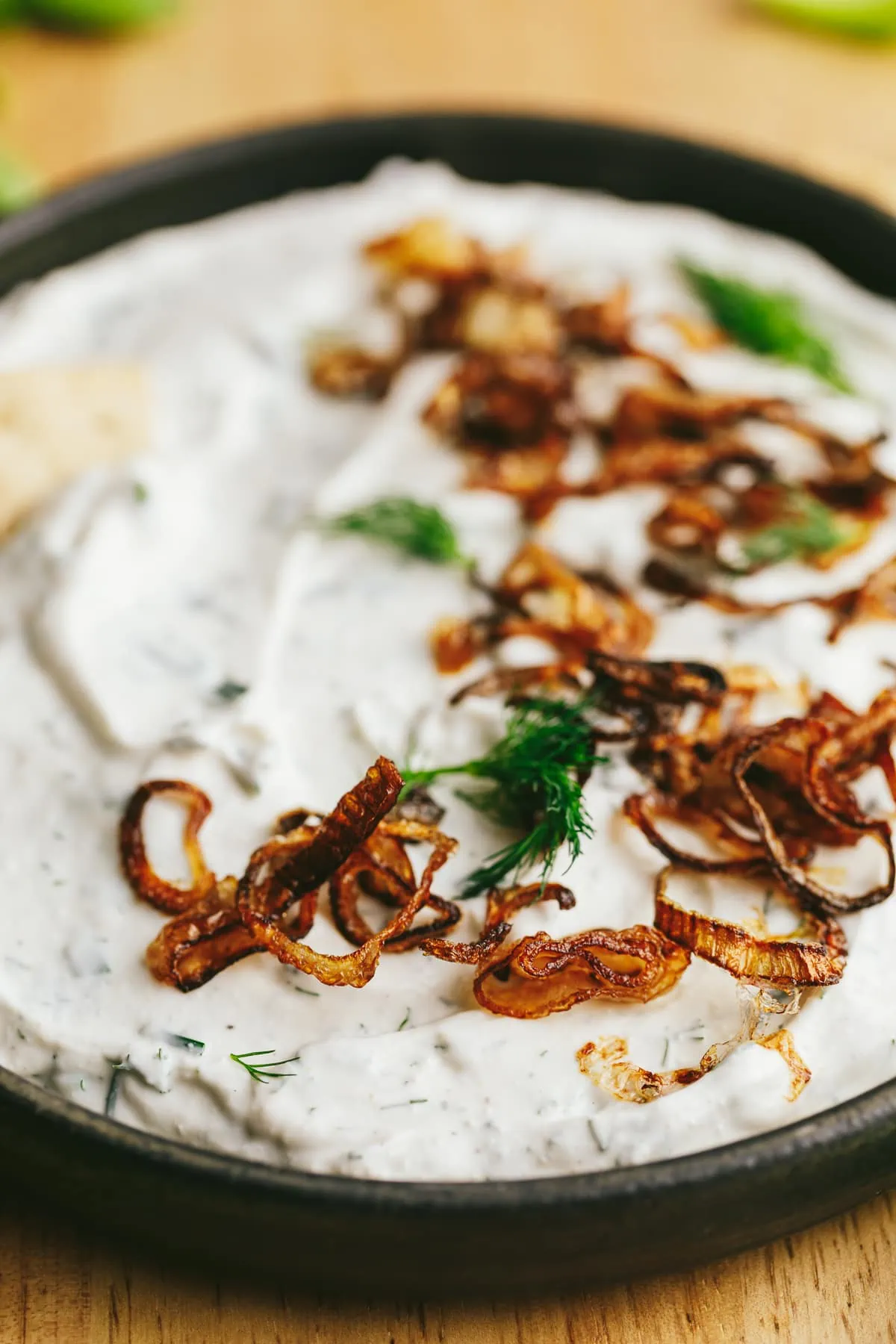 Closeup of crispy shallots on cottage cheese dip.