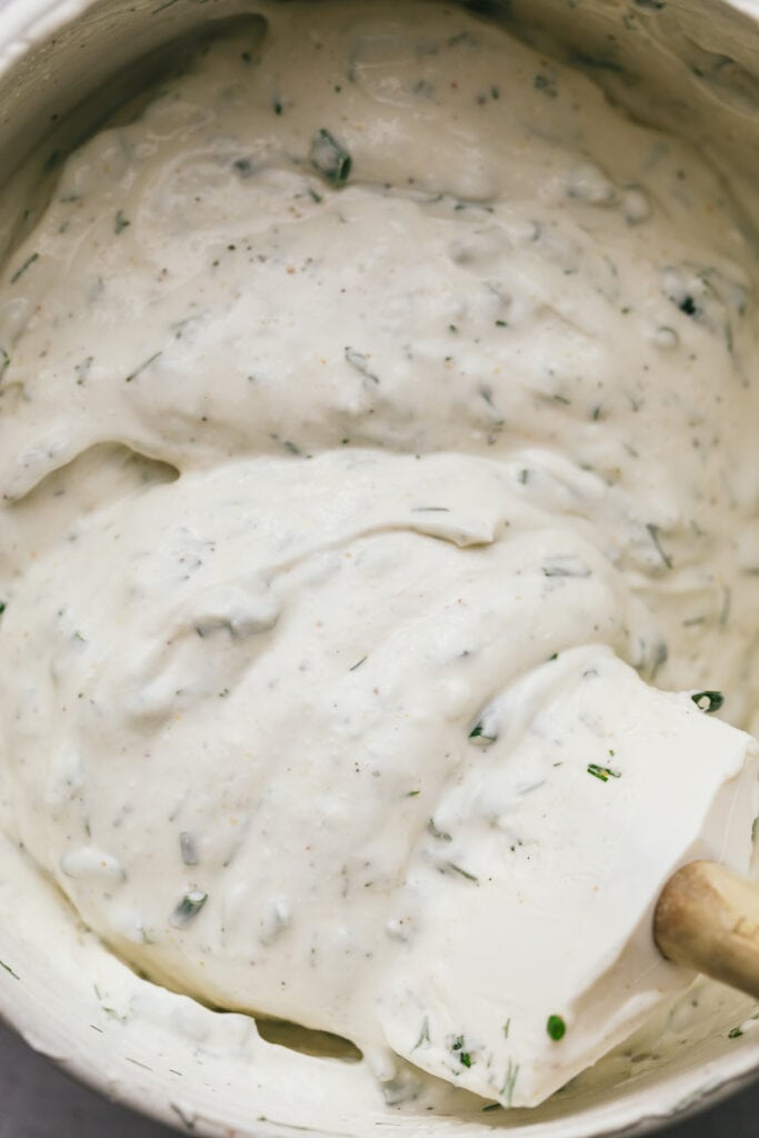 Whipped cottage cheese dip with herbs and a spatula.