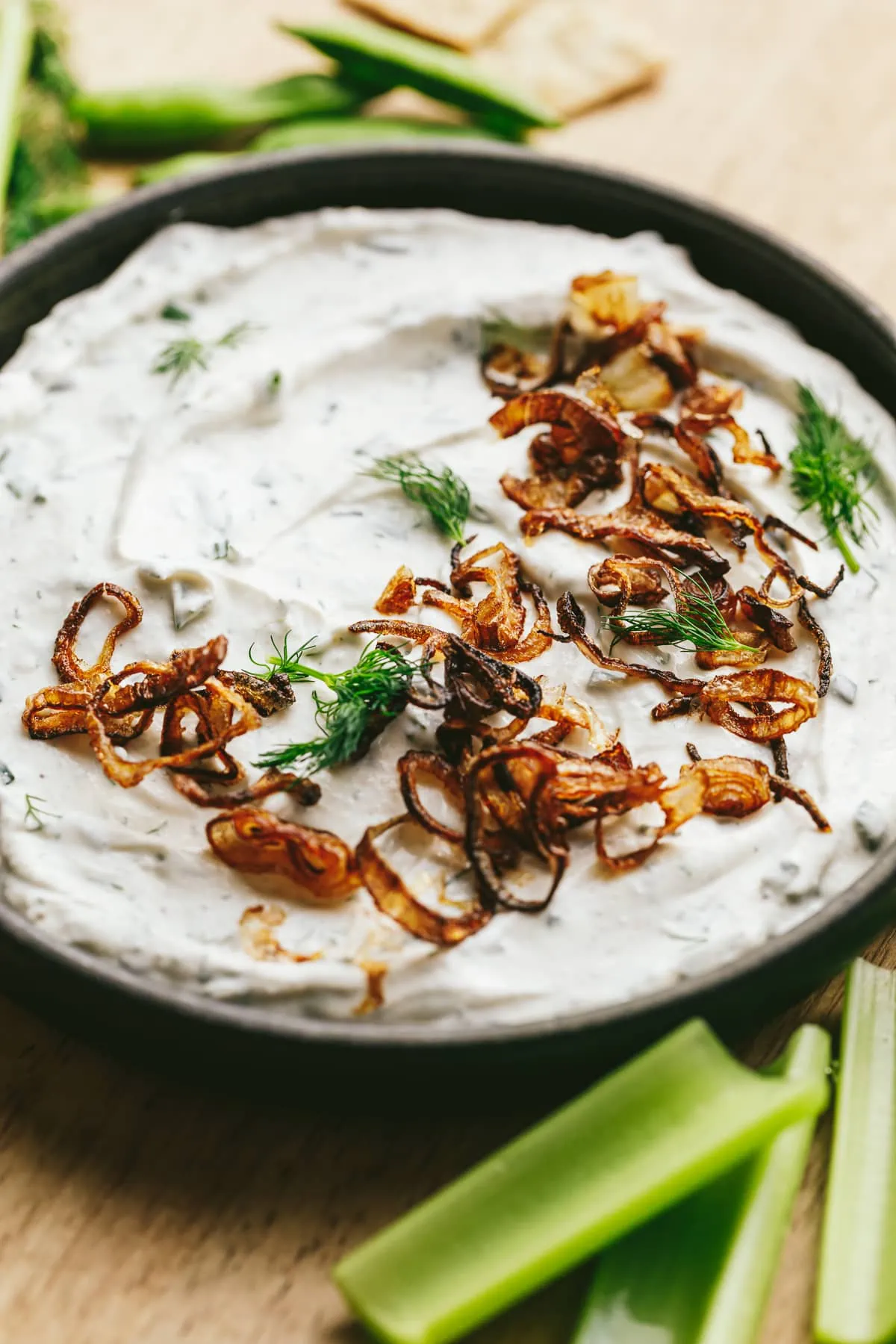 Cottage cheese dip with dill garnish and celery.