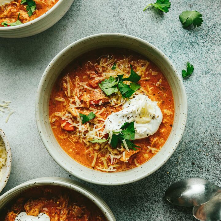 A bowl of keto pumpkin chicken chili with sour cream and cilantro.