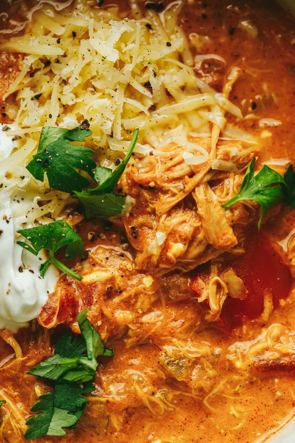 Closeup of shredded chicken in a bowl of crockpot pumpkin chili.