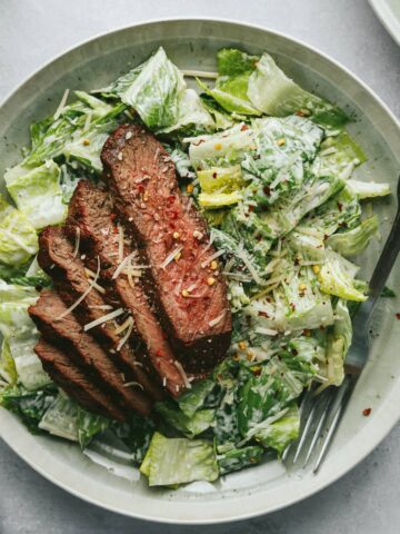Steak Caesar salad on a plate with a fork.