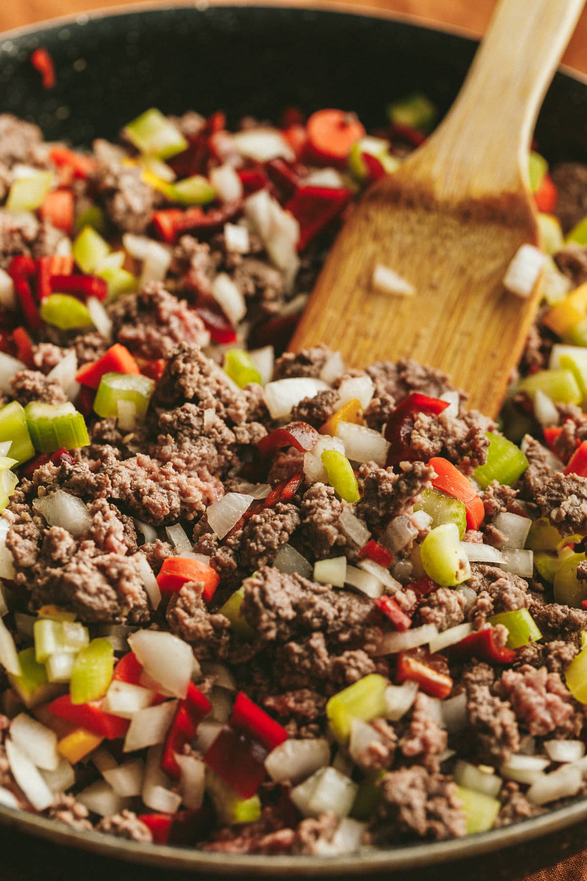 Browning the meat in a skillet with onions, celery and peppers.