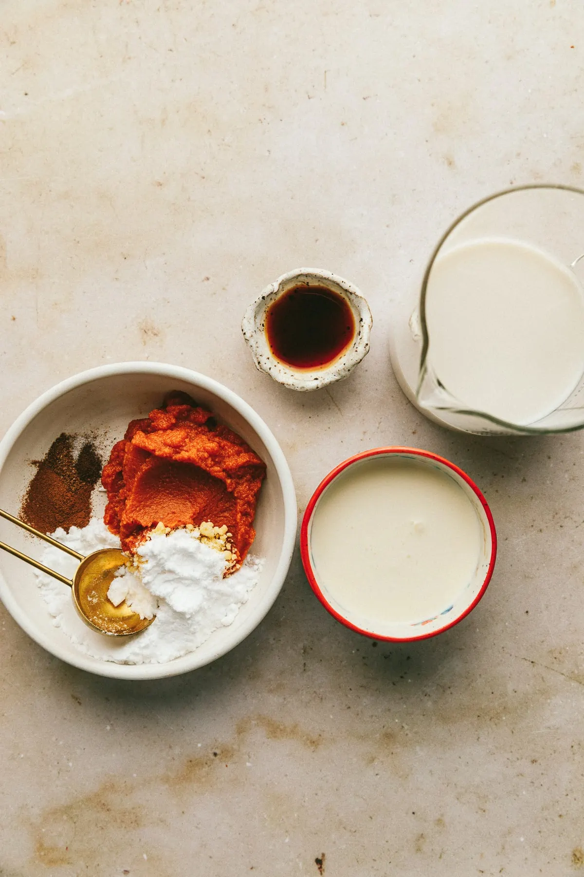 Ingredients for keto pumpkin creamer on a marble backdrop.