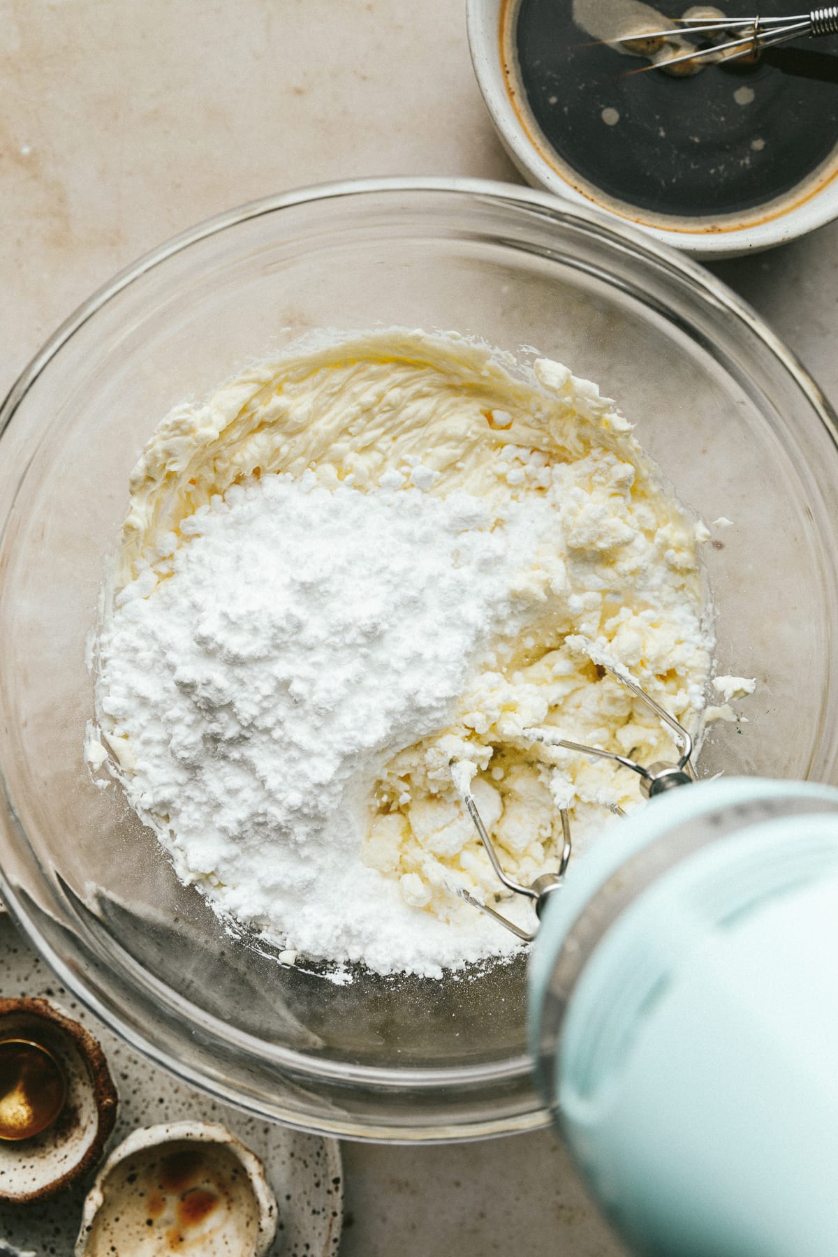 Mixing powdered monk fruit sweetener into cream cheese and mascarpone.