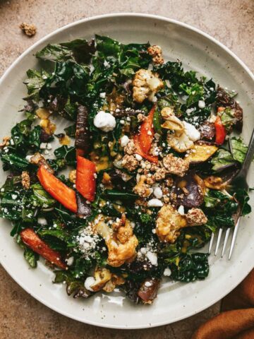 A serving of fall kale salad on a salad plate with a fork.