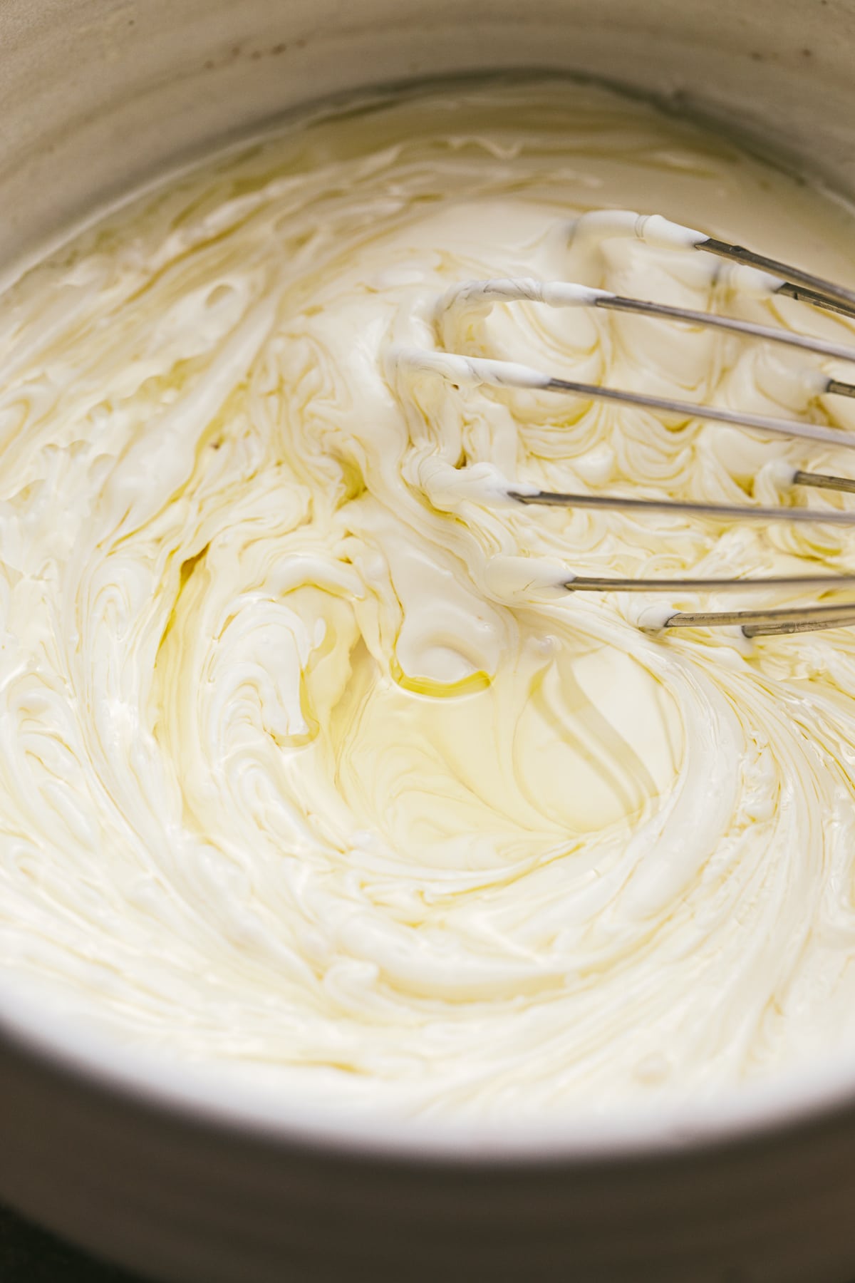 Closeup of truffle oil being whisked into avocado oil mayonnaise.