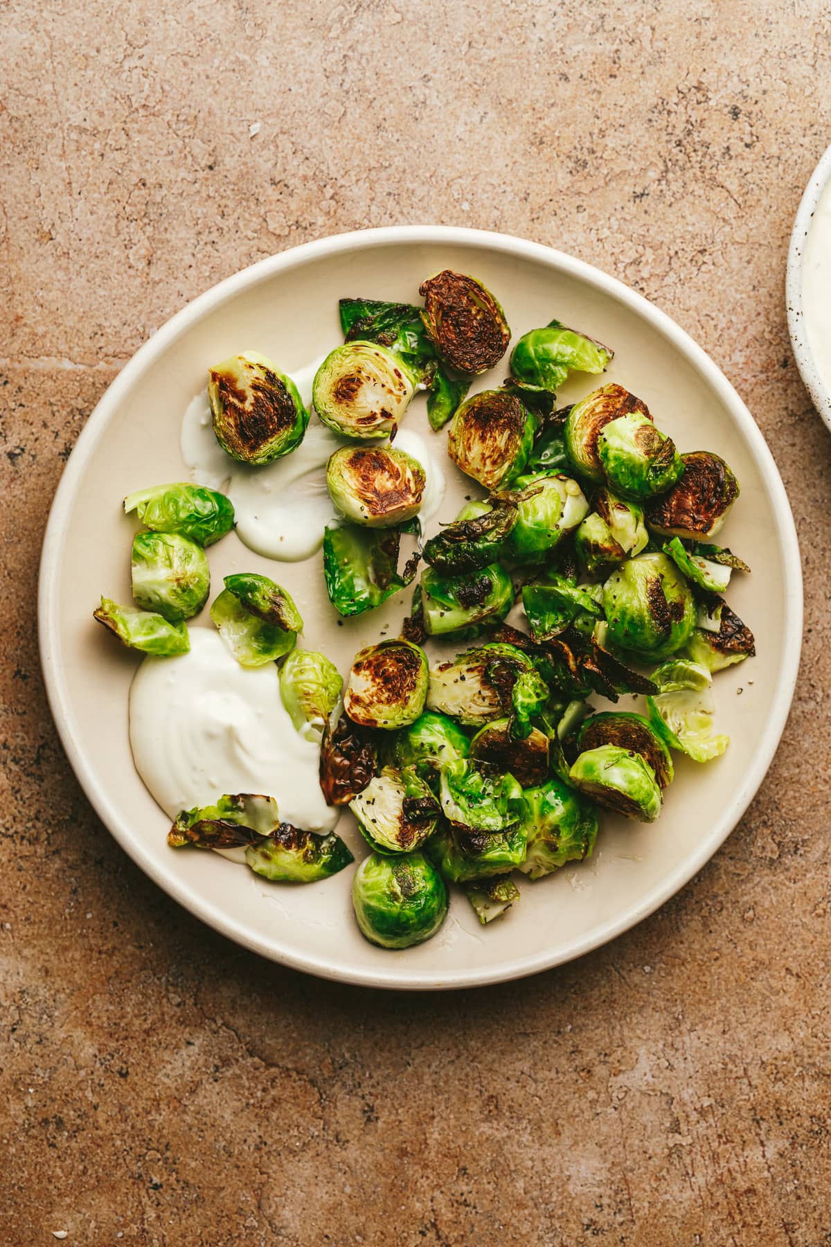 A plate of roasted Brussels sprouts with truffle aioli for dipping.