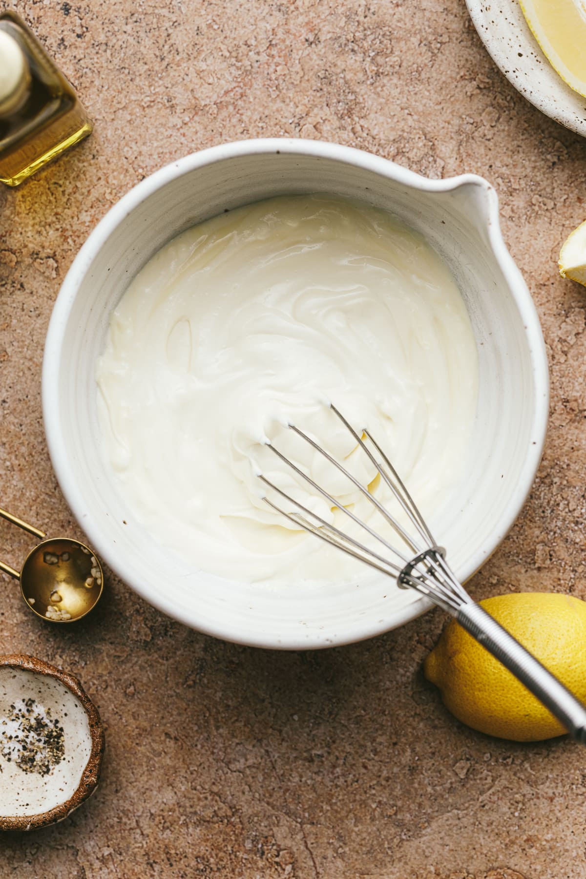 Ingredients for truffle aioli arranged on a brown surface.