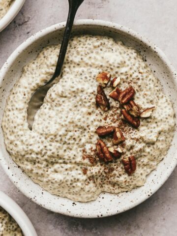 A bowl of warm chia pudding with chopped pecans.