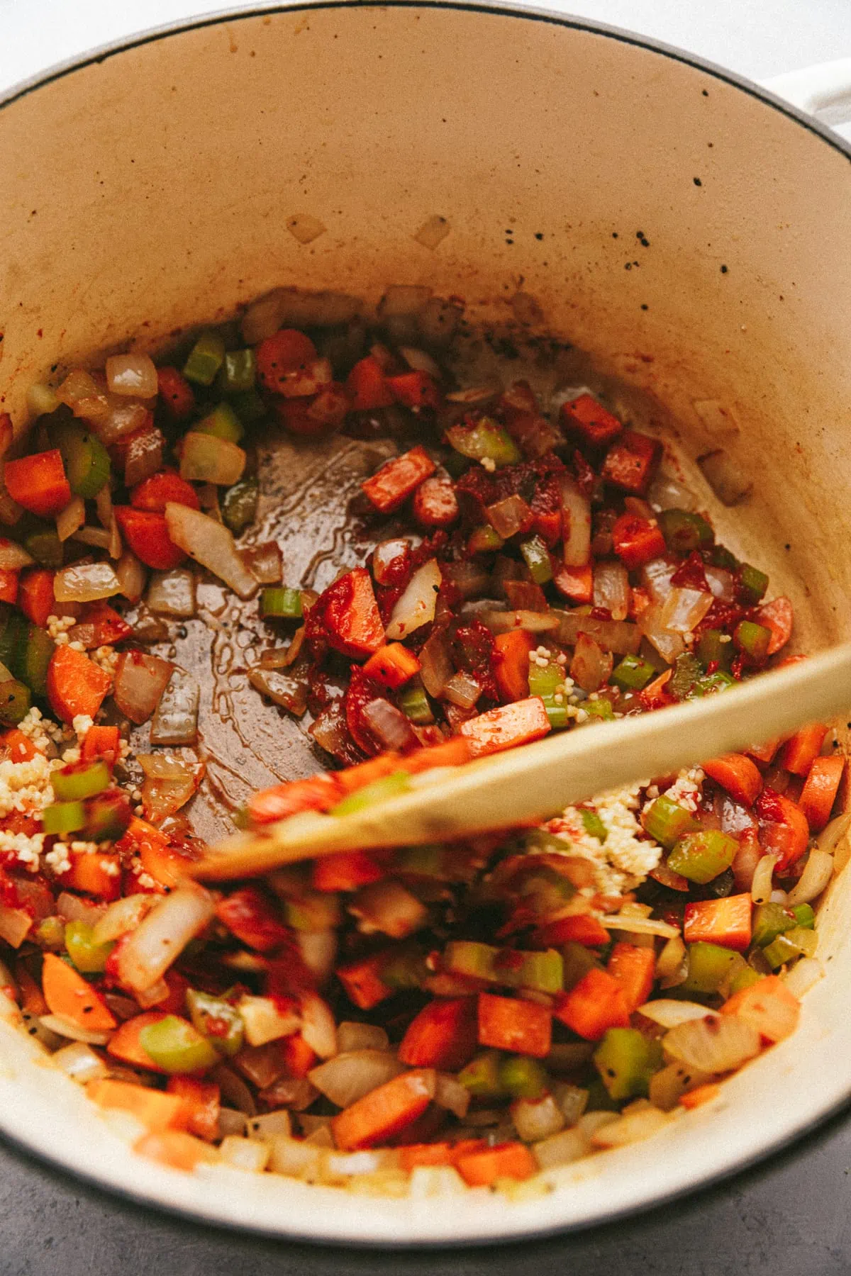 Carrots, onions and celery with garlic and tomato paste in a Dutch oven.