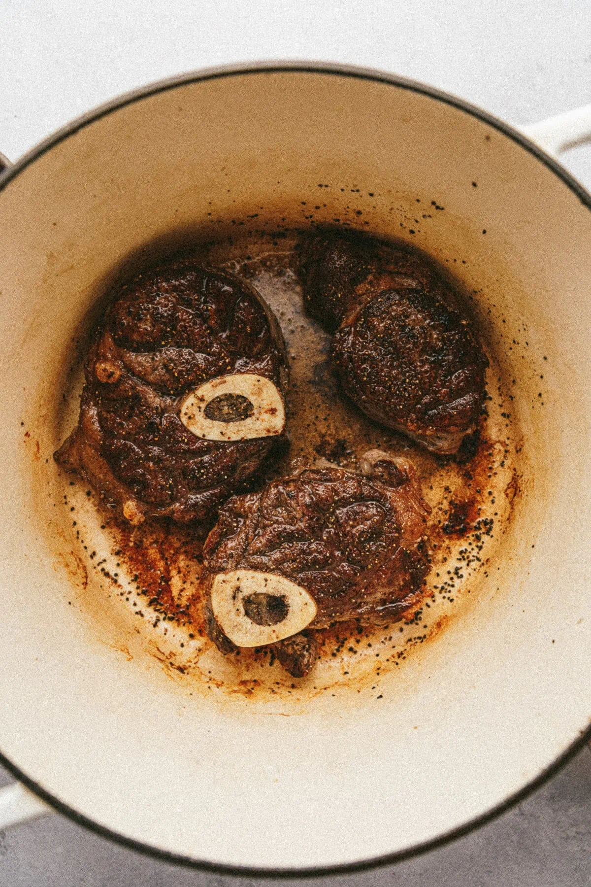 Braised beef shanks in Dutch oven before braising.