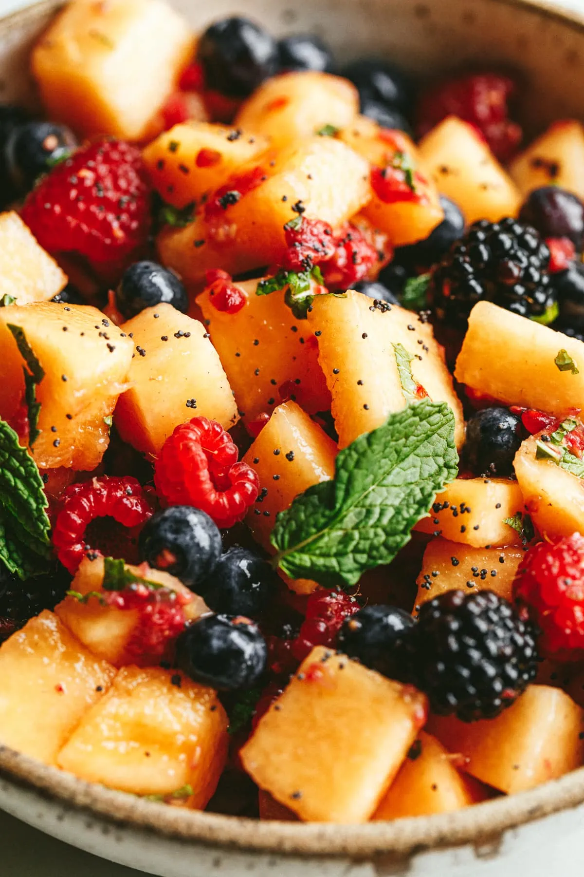 Closeup of a prepared bowl of low carb fruit salad with fresh mint as garnish.