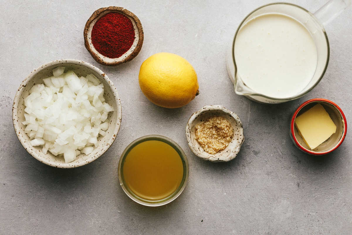 Ingredients on a gray surface for making paprika sauce.
