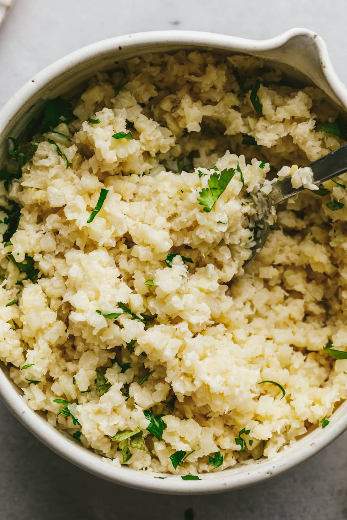 Closeup of coconut cauliflower rice with chopped cilantro in a bowl.