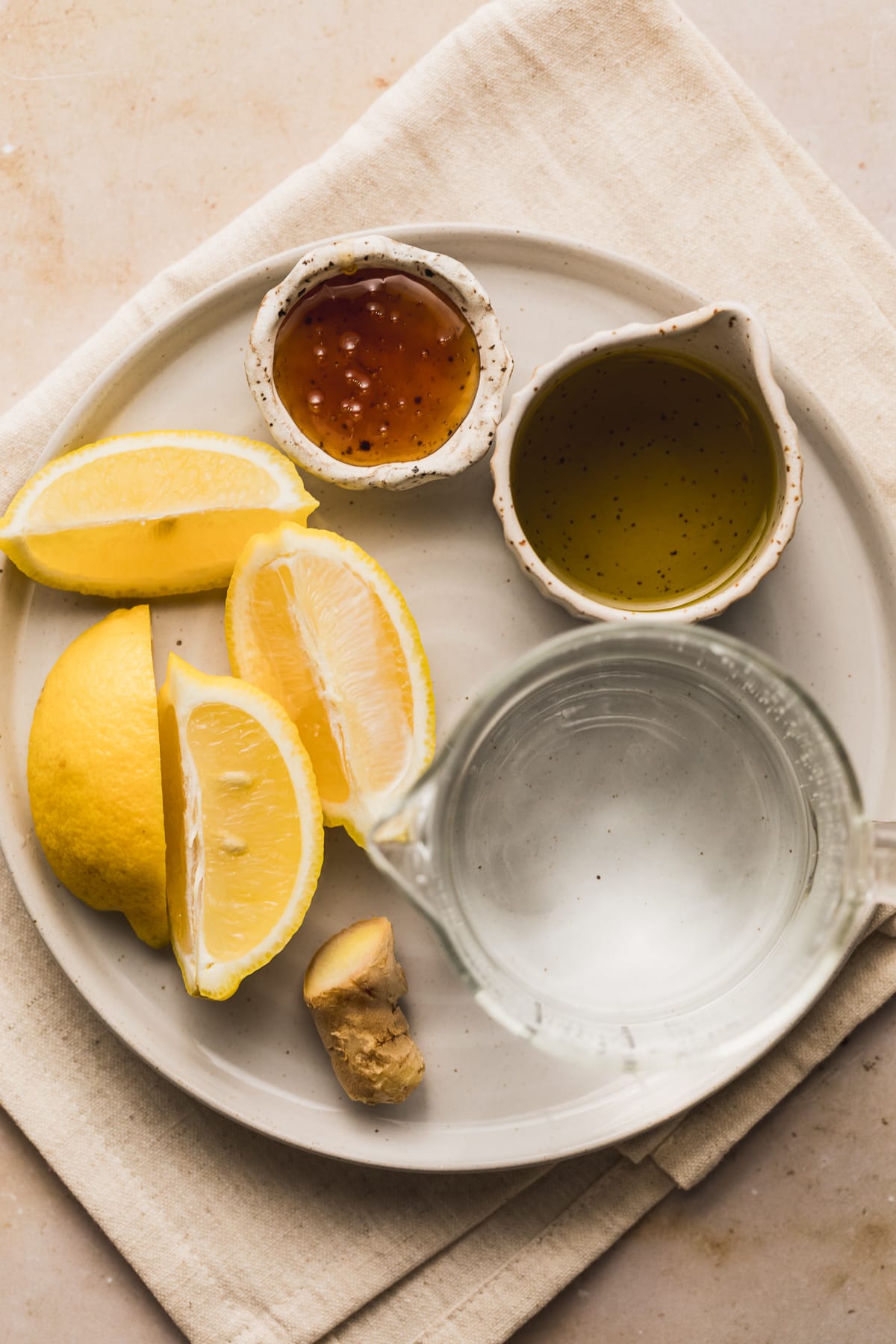 Ingredients for olive oil and lemon juice drink on a plate.